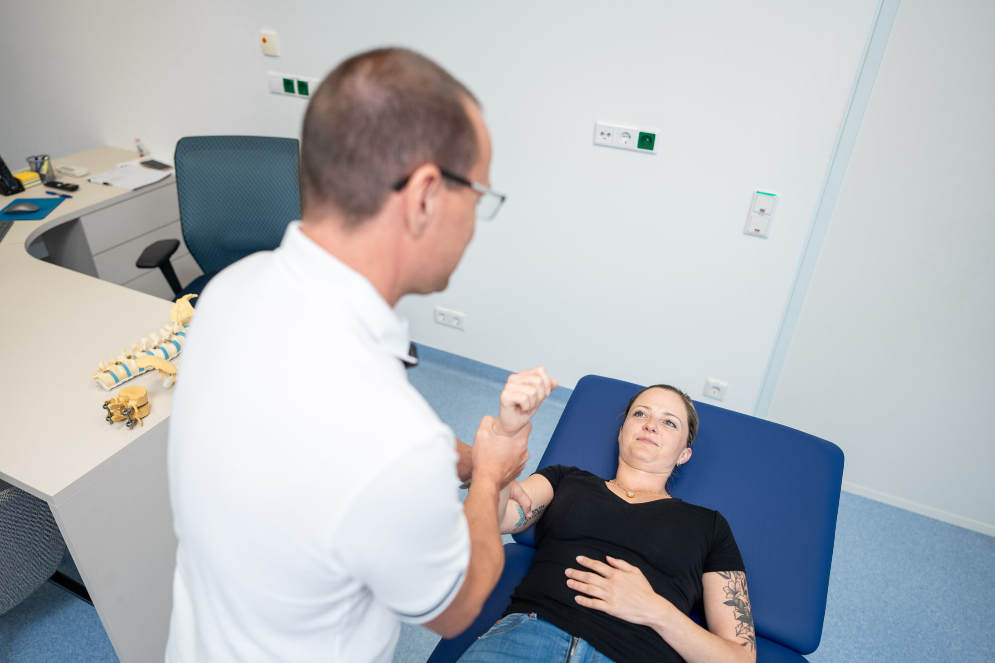 DDr. Mrfka bei der Kraftprüfung am Arm einer Patientin